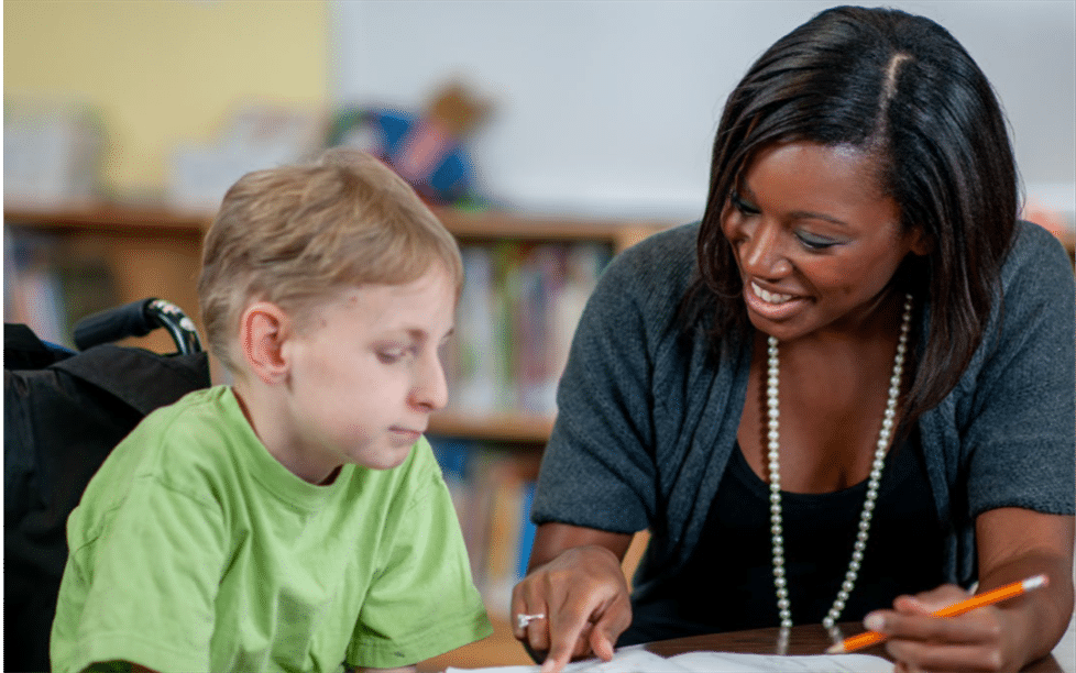 Boy reading with teacher